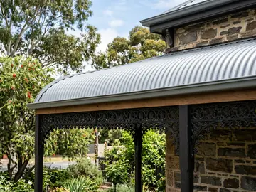 Bullnose verandah roof in new corrugated iron above cast-iron lace