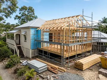 Rear extension framing and roof trusses going up on a Queenslander